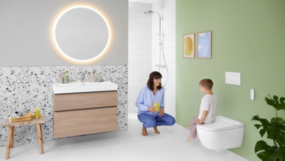 Жінка та дитина у ванній кімнаті з унітазом-біде Geberit AquaClean Alba Жінка та дитина у ванній кімнаті з унітазом-біде Geberit AquaClean Alba