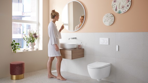 Жінка у ванній кімнаті з унітазом-біде Geberit AquaClean Alba