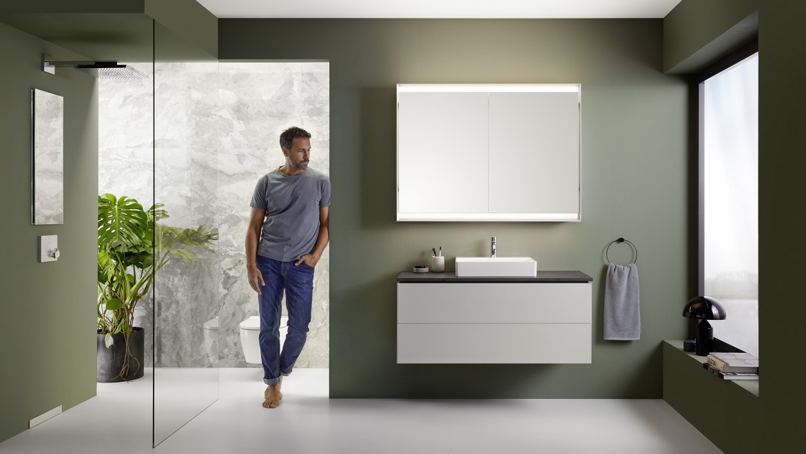 Чоловік стоїть у ванній кімнаті із серії Geberit ONE