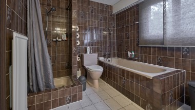 Ванна кімната з вузьким душовим куточком, ванною та підлоговим туалетом