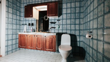 Ванна кімната з синьою плиткою та підлоговим унітазом