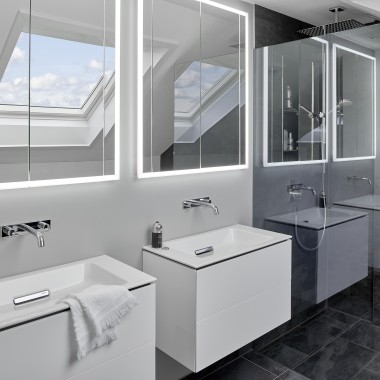 Ванна кімната під дахом з двома умивальниками і дзеркалами