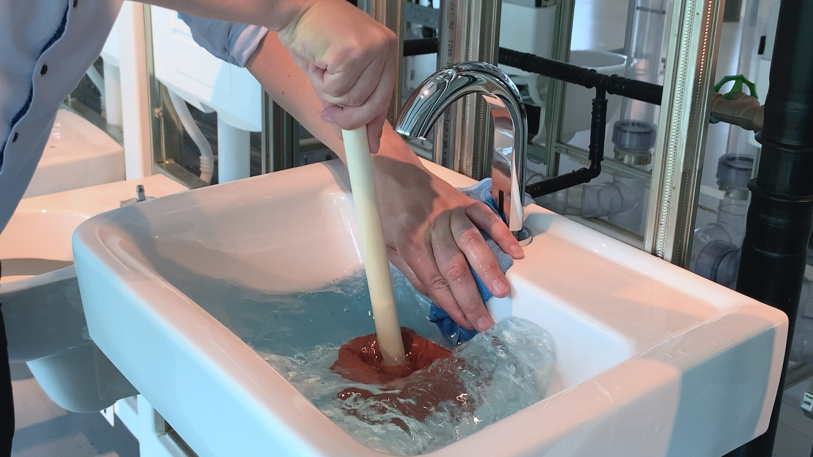 Закрийте отвір переливу рукою та шматком тканини Закрийте отвір переливу рукою та шматком тканини