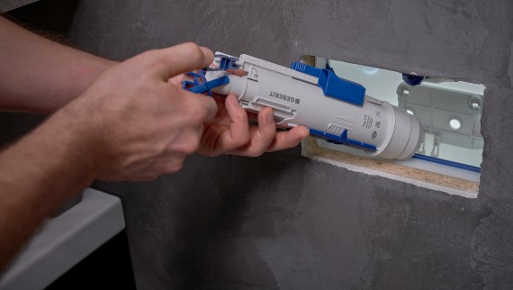 Чоловік встановлює зливний клапан Geberit у прихований бачок (© Ben Huggler) Чоловік встановлює зливний клапан Geberit у прихований бачок (© Ben Huggler)